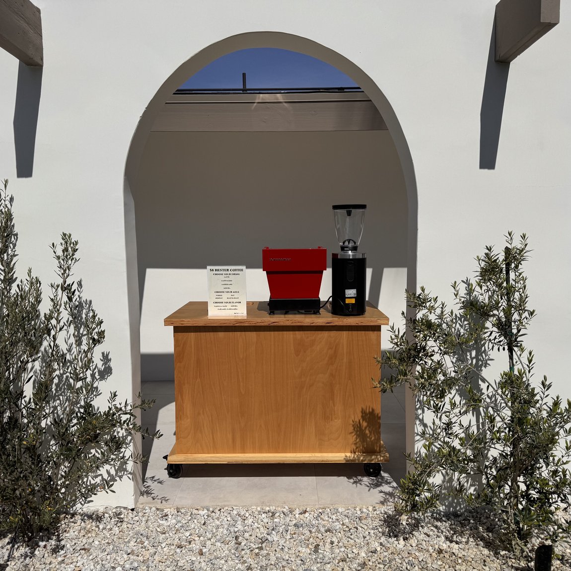 58 Hester premium coffee cart under a white archway with olive trees